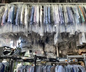 Clothing on racks at Dry cleaners. PFAS regulations in Dry Cleaning.